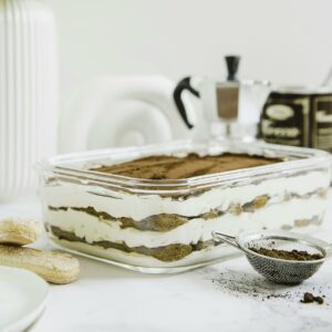 Beautiful layered tiramisu dessert with a coffee-focused setup, styled indoors in Riyadh.