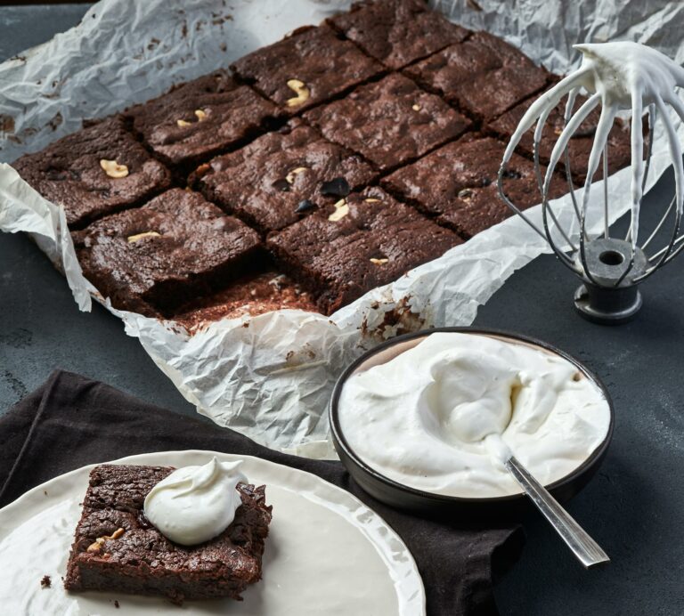 Mouth-watering brownie served with whipped cream, perfect for dessert lovers.